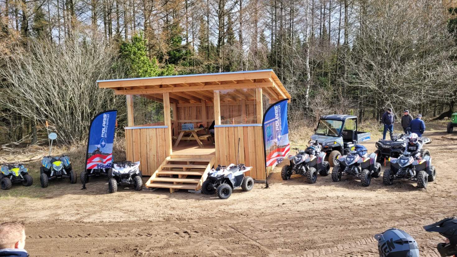 Ny træpavillon med Polaris-flag og en række ATV-maskiner opstillet